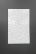 A rectangular white textured panel featuring an embossed pattern of overlapping circles, displayed against a dark gray background.