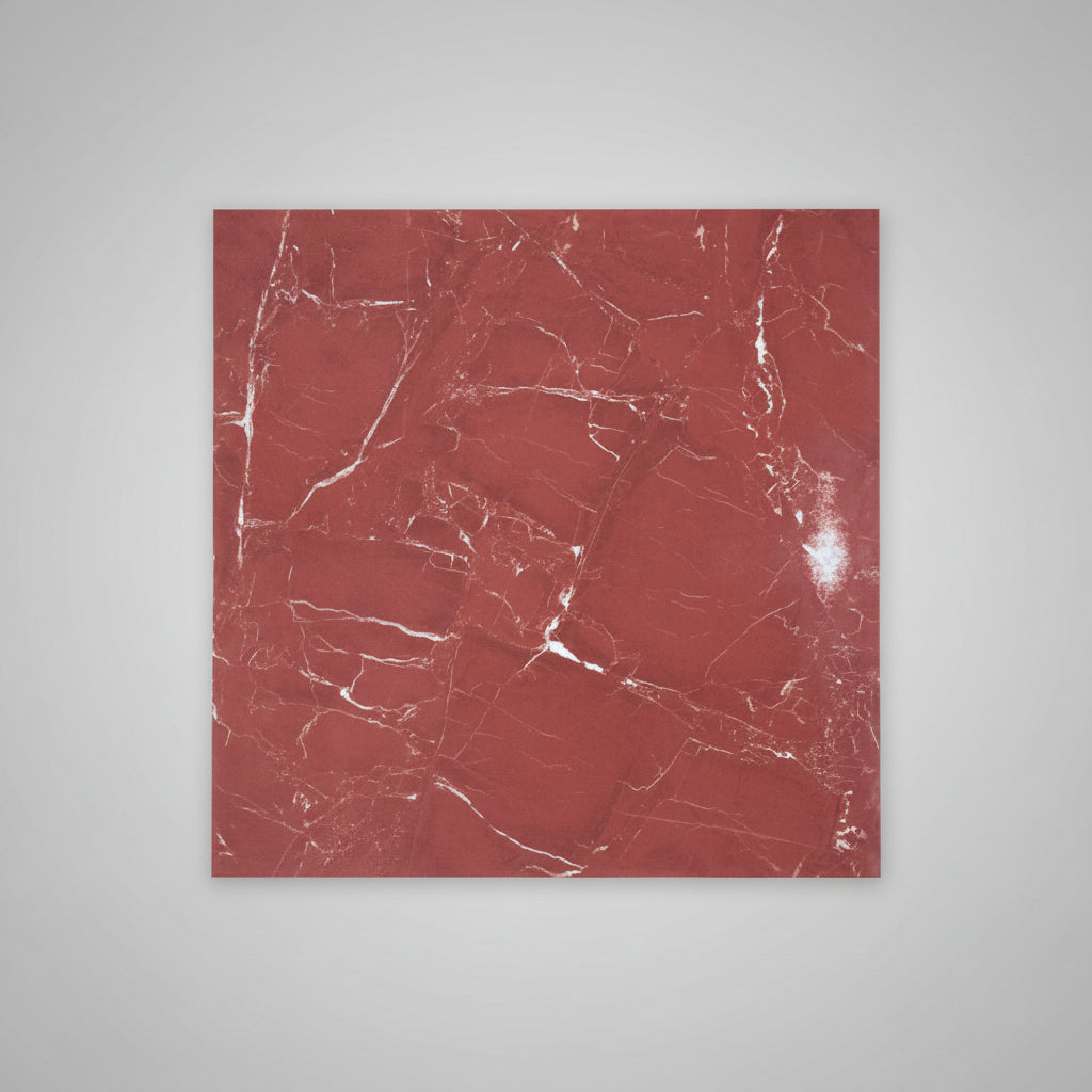 A square red marble-patterned tile lies on a beige tiled floor next to a person's legs wearing blue jeans and brown sandals.