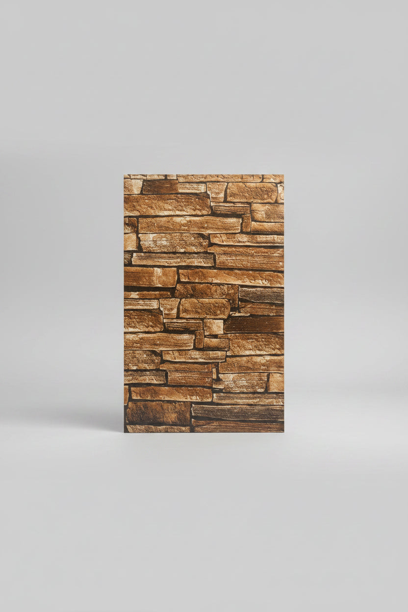 A rectangular sample tile of faux stacked stone wall cladding with brown and beige tones, placed on a light beige tiled floor. A person's foot wearing a brown sandal is visible at the bottom edge.